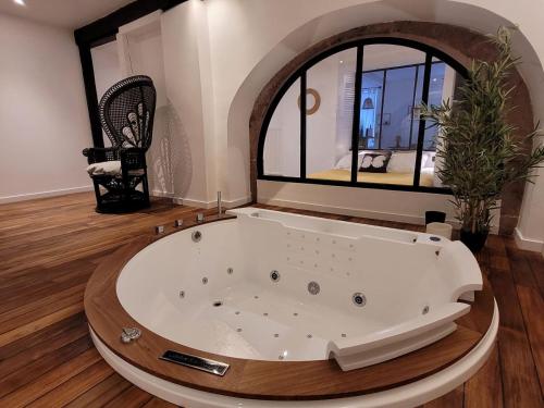 希伯维列Jacuzzi des Tanneurs的设有一个大浴缸的大窗户