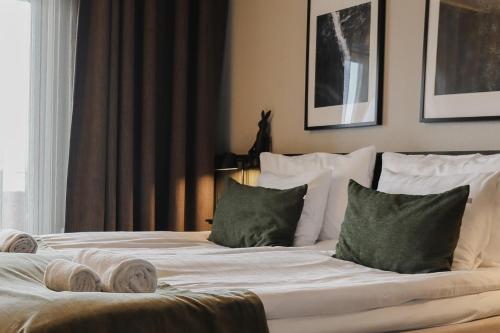 SiljansnäsSiljansnäs Hotell的一张带白色床单和绿色枕头的床