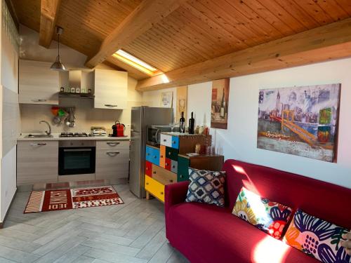 卡塔尼亚Casa Alcalà Deluxe的一间带红色沙发的客厅和一间厨房