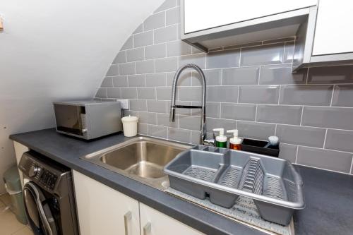 索利赫尔Comfortable stay in Shirley, Solihull - Room-2的厨房水槽旁设有碗碟干燥架