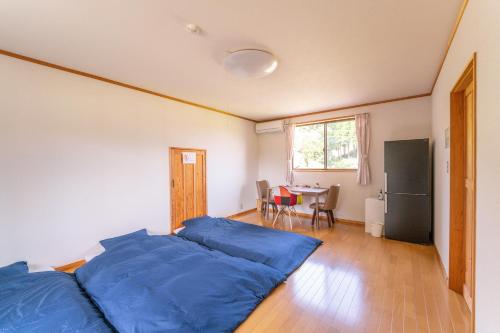 武雄市分享创意住宿阿多诺安乡村民宿的一间卧室配有一张带蓝色床单的床和一张桌子。