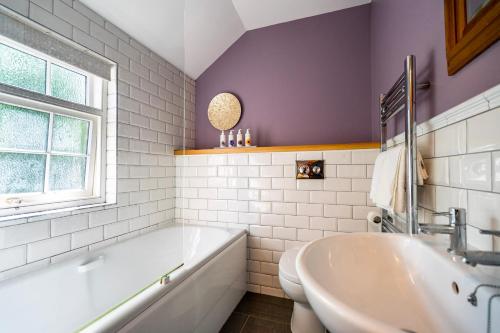 约克Middlethorpe Manor - No 4 Relaxation and Peace的带浴缸、水槽和窗户的浴室