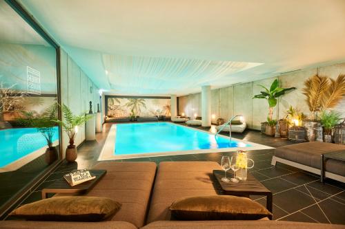 不莱梅昂贝弗拉斯设计酒店的一间带游泳池和沙发的客厅