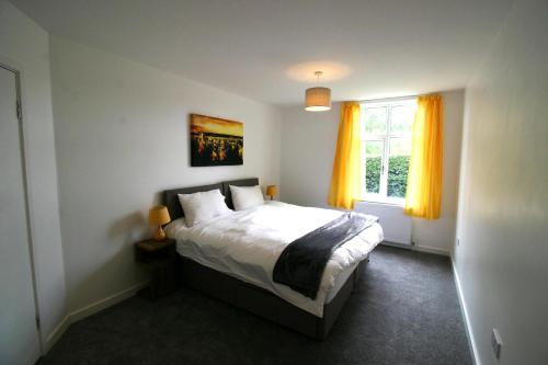 约克Garden House at The Red House Estate的一间卧室设有床和黄色窗帘的窗户