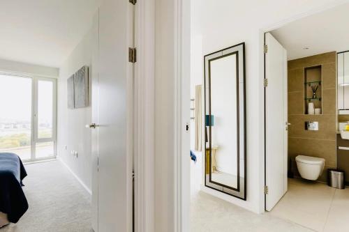 WoolwichExecutive Waterfront Split Penthouse的白色的浴室设有镜子和卫生间