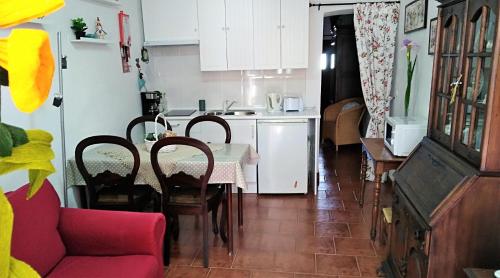 DegoladosCasa BENVINDHA的厨房以及带桌子和红色沙发的用餐室。