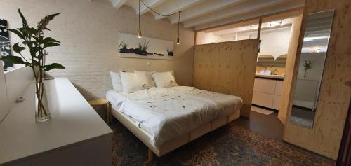 沃德里赫姆Waar Maas & Waal.....的一间带白色床的卧室和一间厨房