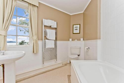 Strachur克里甘斯酒店的白色的浴室设有盥洗盆、卫生间和窗户。