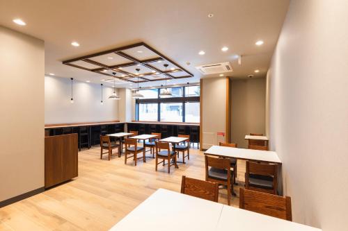 名古屋Sotetsu Fresa Inn Nagoya-Shinkansenguchi的一间在房间内配有桌椅的餐厅