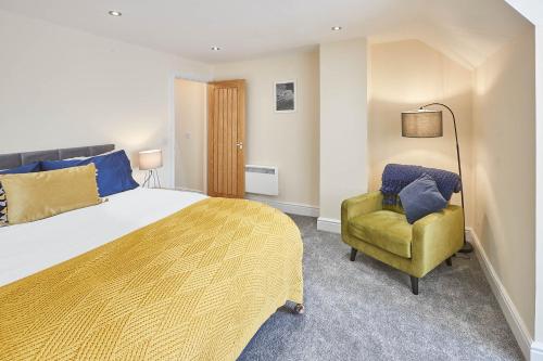 TotleyHost & Stay - Baslow Road, Serviced Apartment的一间卧室配有一张大床和一张黄色椅子