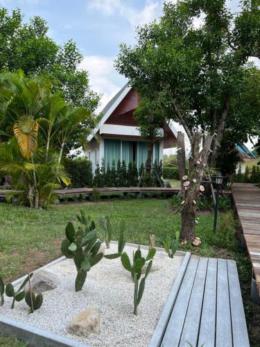 农布Sirilagoona Home Resort的房屋前设有木凳的花园