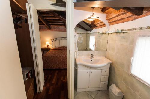 帕多瓦贝托里尼公寓式酒店的一间带水槽的浴室和一张位于客房内的床