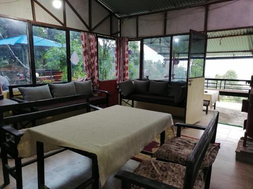 纳加阔特Jungle Crown Organic Homestay的客房设有桌椅和窗户。