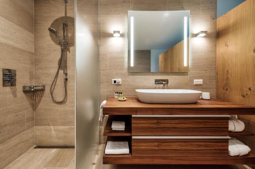 达沃斯Alpen panorama luxury apartment with exclusive access to 5 star hotel facilities的一间带水槽和淋浴的浴室