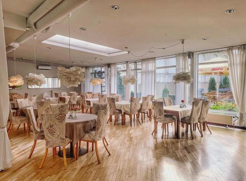 里加NB Hotel with Free Parking的用餐室设有桌椅和窗户。