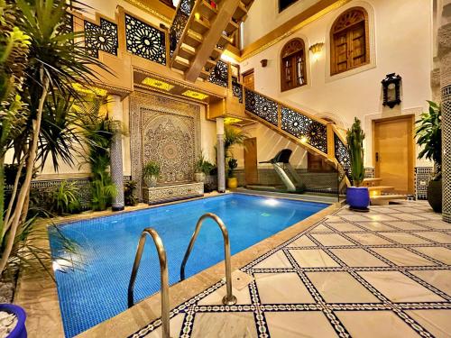 非斯Riad Marjana suites & Spa的庭院中带游泳池的房子
