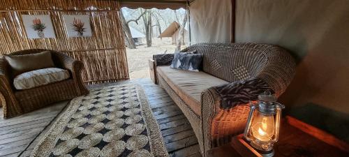 蓬戈拉Somkhanda Game Reserve的一个带沙发和椅子的帐篷门廊