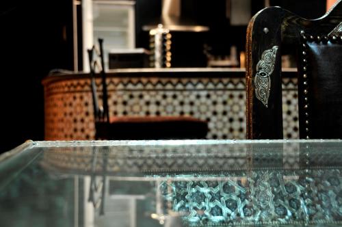 非斯Luxury Riad Saad Fes- Apart的桌子和椅子,在柜台前