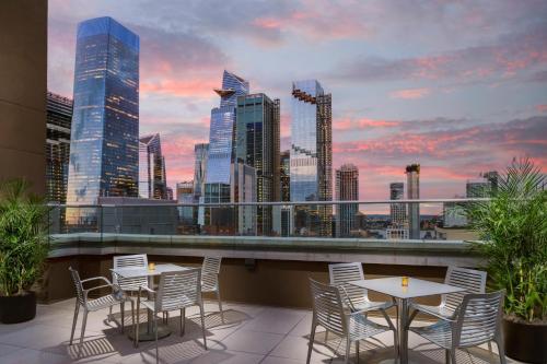 纽约DoubleTree by Hilton New York Times Square South的一个带桌椅的屋顶露台,享有城市天际线
