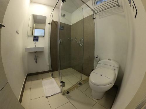 圣何塞德尔瓜维亚雷Hotel Quinto Nivel的一间带卫生间和玻璃淋浴间的浴室