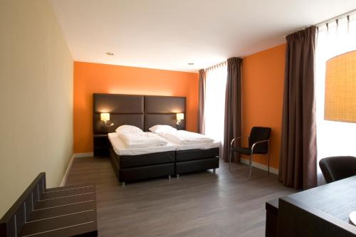 鲁尔蒙德鲁尔蒙德隔壁酒店的一间卧室配有一张橙色墙壁的床