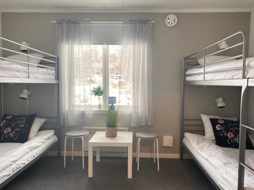 VallstaÅsbergbo Vandrarhem的客房设有两张双层床、一张桌子和一扇窗户。