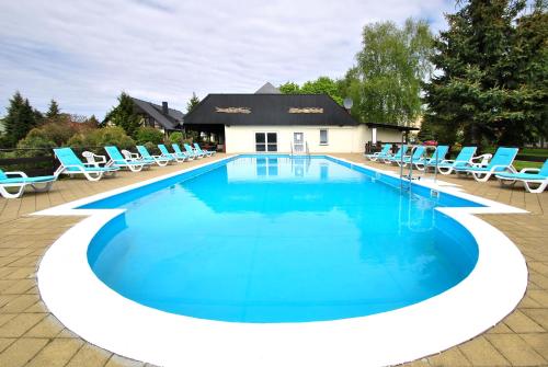韦巴莱赫度假Spa度假村的周围设有蓝色躺椅的大型游泳池