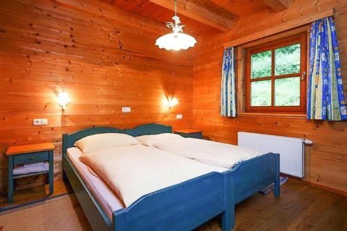 斯利耶巴赫Holiday Village, Schlierbach的一间位于木制客房内的卧室,配有一张蓝色的床