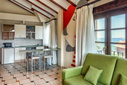苏安塞斯翡翠海岸公寓的一间带绿色沙发的客厅和一间厨房