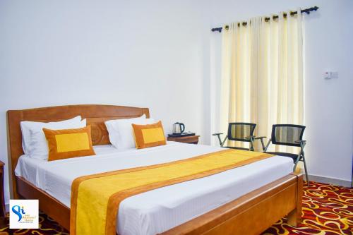 波隆纳鲁沃Hotel Summer Haven的一间卧室配有一张带黄色和白色枕头的大床