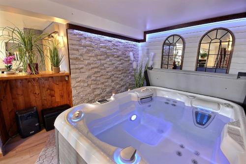 斯姿Spa et romance à Molliebon的砖墙客房内的大浴缸