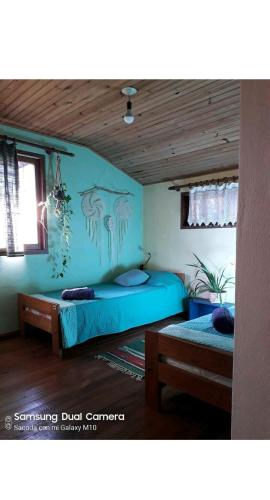 伊瓜苏港Jardín de Naipí 3的一间卧室设有两张床和蓝色的墙壁