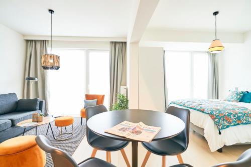 布鲁塞尔Diamant Studio的卧室配有一张床和一张桌子及椅子