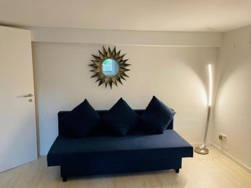 杜塞尔多夫Souterrain Zimmer mit separatem Eingang und Bad的客厅配有蓝色沙发,设有镜子