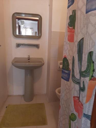 格兰贝伊Obelix Apartment的一间带水槽和淋浴帘的浴室