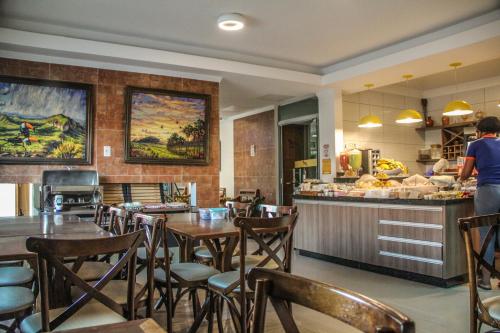 戈亚斯州上帕莱索Pousada Araras的一间带桌椅和柜台的餐厅