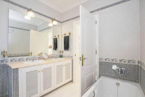 桑帕克Menorca Villa Marbella的白色的浴室设有浴缸和水槽。