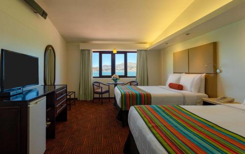 普诺普诺德尔印加圣淘沙集团酒店的酒店客房设有两张床和一台平面电视。