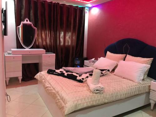 塞拉appartement luxueux à Rabat的一间卧室配有一张带梳妆台和镜子的床