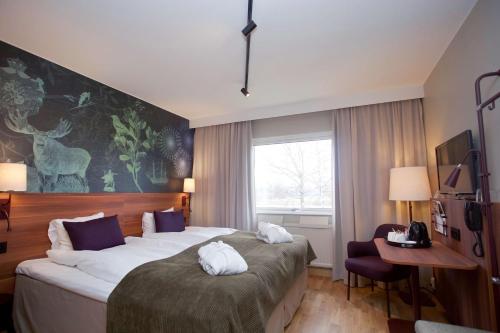 卡尔斯塔德斯堪迪克卡拉文酒店的酒店客房设有一张大床和一张书桌。