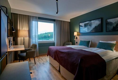 恩舍尔兹维克恩舍尔兹维克斯堪的克酒店的配有一张床、一张书桌和一扇窗户的酒店客房