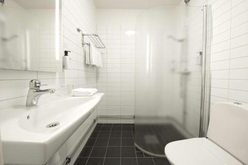 恩舍尔兹维克恩舍尔兹维克斯堪的克酒店的白色的浴室设有水槽和淋浴。