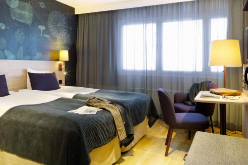厄勒布鲁斯堪迪克厄勒布鲁瓦斯特酒店的配有一张床和一把椅子的酒店客房