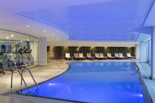 KemalpaşaRamada Hotel & Suites by Wyndham Izmir Kemalpasa的一个带健身房的酒店游泳池