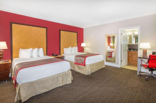 迈阿密迈阿密温泉/迈阿密国际机场华美达酒店的红色墙壁的酒店客房内的两张床