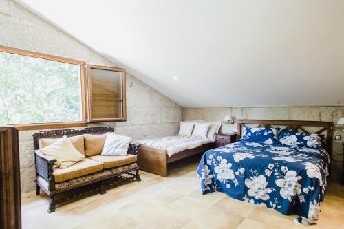 托米尼奥Villa Casa de Campo Los Carballos的一间卧室配有一张床、一张沙发和一个窗口