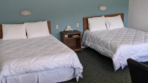 MattawaValois Motel & Restaurant的酒店客房设有两张床和床头柜。