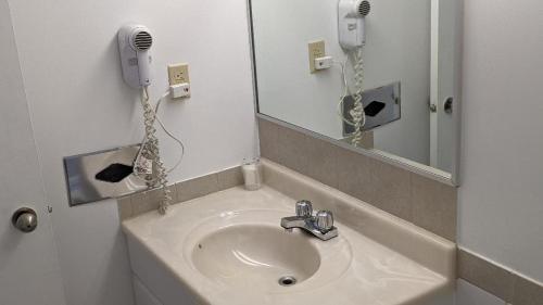 MattawaValois Motel & Restaurant的一间带水槽和镜子的浴室