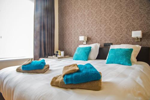 奥斯坦德尚布尔多住宿加早餐旅馆的一张带蓝色枕头的大型白色床