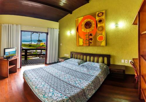 乌巴图巴Hotel Pousada do Sol的一间卧室配有一张床、一台电视和一个窗口